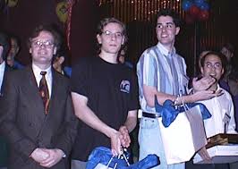 Waterloo at the 1998 ACM Programming Contest world Finals. left to right: Gordon Cormack (coach), Derek Kisman, Christopher Hendrie, David Kennedy. - Water