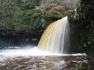 rock on the river bed is hidden under brown churning water and the noise - via Daymix