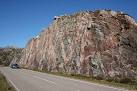 The pale parallel stripes are the shot holes drilled to blast the rock. - via Daymix