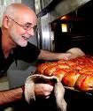 BAKER'S DELIGHT: Bob Bateman pulls a fresh batch of Red Cross buns out of ... - 4755593