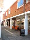 Chairs and tables are out in front of Aroma, a hot and cold drinks bar, - via Daymix