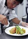 Chef and co-owner Quang Tran finishes a plate of pan-seared salmon. - Mes_Reves_3