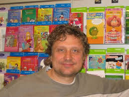 De aimabele ondernemer John Pijpers voor een kaartenrek in zijn winkel (Foto: Dirk Bosman). Aan de Adelaarslaan in Apeldoorn in winkelcentrum Hart van Zuid ... - JohnPijpers