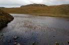 A small loch trapped behind a rock band above the sea cliffs. - via Daymix
