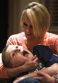 Mitchell Jones and his mom, Natalie, react at the sound of a knock at the door from former BYU and NFL football player Andrew Rich Sunday, Feb. 24, 2013. - 1088566