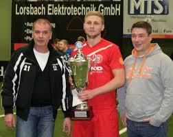 Fortuna-Vorsitzender Karsten Klappert und Turniersponsor Lutz Waffenschmidt überreichten Eugen Litter von der U23 der Sportfreunde Siegen den Siegerpokal.