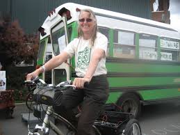 Patricia Menzies of Sustainable Tacoma-Pierce County astride her electric trike, posing in front of her nationwide touring bus filled with literature on ... - men-fair-2012-patricia-electric-trike-w-bus