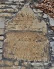 The inscription translates as "In the memory of the departed; to the name of - via Daymix