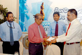 SLIC Director Damien Fernando presents the sponsorship cheque to ANCL Chairman Janadasa Peiris. Co-sponsor of the event- HNB- General Manager Rajendra ... - z_p01-SLIC