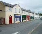 The four shops nearest the camera are Honddu Wholefoods; vacant premises; - via Daymix