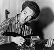Woody Guthrie with guitar