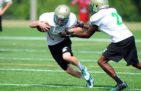 Buford's Michael Lane (1) tries to break a tackle by Thomas Wilson (21).