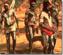 Soldiers watching three Aboriginal men posing in traditional body 