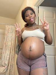 A pregnant woman strokes her belly in front of the mirror light stripes on the belly jpg x Pregnant women videos