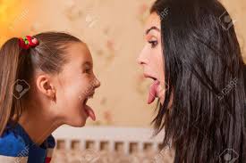 mother daughter tongue|Mother and daughter with sticking out tongues taking selfie at desk on  blurred foreground Stock Photo - Alamy