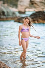 beach little garl|かわいい女の子がビーチでくつろいでいる。彼女は船と日光浴の隣に立っている。写真素材1495139393 | Shutterstock