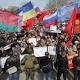 Crowds of demonstrators waving Russian flags storm government buildings ...